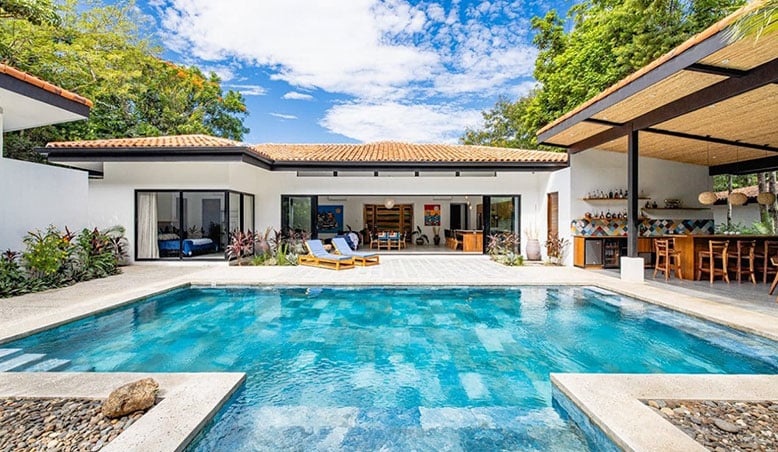 Luxurious backyard with a crystal-clear swimming pool and inviting lounge chairs, showcasing an inviting open-plan living space perfect for homeowners looking to sell your house